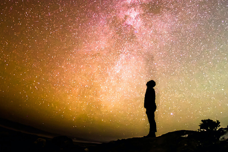Silhouette of a person looking up at the stars.